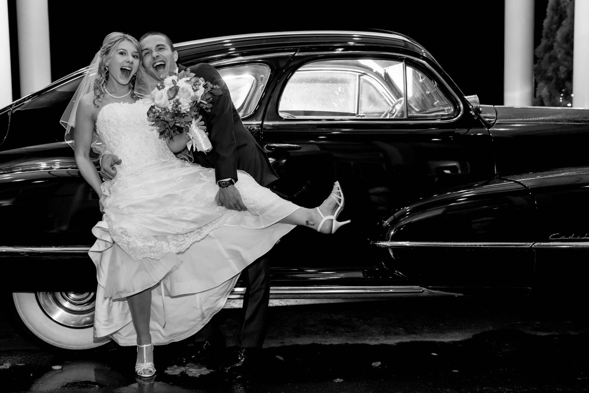 Fun photo of bride and groom on side of car - White Mountains Wedding Photography