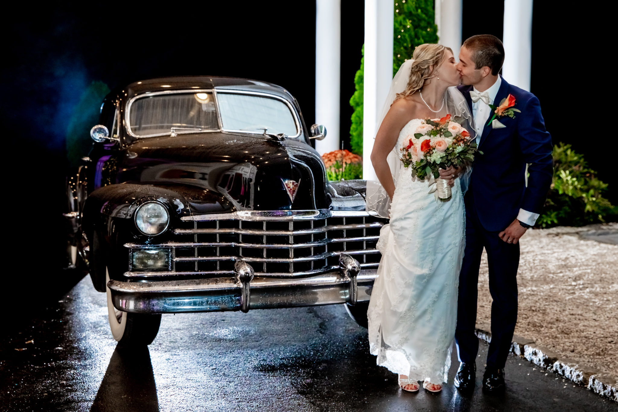 Bride and groom kissing in front of black antique car - White Mountains Wedding Photography