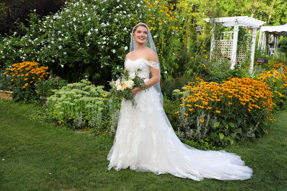 Bride alone in front of flowers - Sweep the of their feet blog